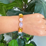 Golden stretch bracelet featuring faceted glass stones in varying shapes, set in a polished gold-tone frame. The elastic design ensures a comfortable fit while showcasing subtle sparkle and refined elegance. Perfect for stacking or wearing solo for a chic touch.