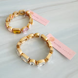 Golden stretch bracelet featuring faceted glass stones in varying shapes, set in a polished gold-tone frame. The elastic design ensures a comfortable fit while showcasing subtle sparkle and refined elegance. Perfect for stacking or wearing solo for a chic touch.