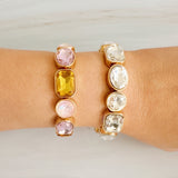 Golden stretch bracelet featuring faceted glass stones in varying shapes, set in a polished gold-tone frame. The elastic design ensures a comfortable fit while showcasing subtle sparkle and refined elegance. Perfect for stacking or wearing solo for a chic touch.