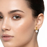 Elegant pearl drop earrings featuring smooth white pearls suspended from sculpted gold loops. The design blends modern artistry with timeless sophistication, creating a refined accessory for everyday or formal wear.