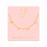 Gold necklace with 'MAMA' on a pink card with 'ELLISON + YOUNG' branding