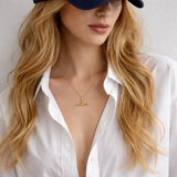 A polished gold chain necklace featuring a T-bar pendant drop at the center. The design highlights a modern, structured silhouette with timeless charm and a subtle statement finish