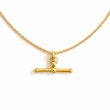 A polished gold chain necklace featuring a T-bar pendant drop at the center. The design highlights a modern, structured silhouette with timeless charm and a subtle statement finish