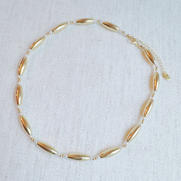Gold-toned necklace featuring sleek tube beads – minimalist and modern layered style