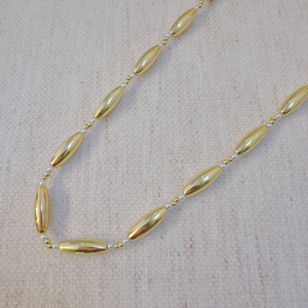 Gold-toned necklace featuring sleek tube beads – minimalist and modern layered style