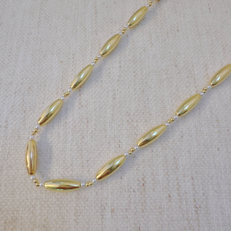 Gold-toned necklace featuring sleek tube beads – minimalist and modern layered style