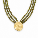 Green beaded necklace with a gold pendant on a white background