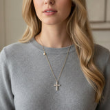 An elegant gold-tone necklace featuring a cross pendant made of luminous pearls with a sparkling crystal at the center. The pendant hangs from a 24-inch chain with a 2-inch extender, creating a timeless and graceful look perfect for layering or wearing solo.