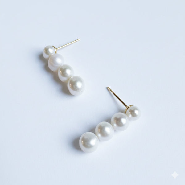 Elegant dangle earrings featuring a graduated design of genuine freshwater pearls in descending sizes. These classic and sophisticated earrings bring a timeless touch to any outfit, perfect for both everyday wear and special occasions.