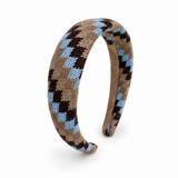 A knitted open-back headband featuring a geometric diamond pattern in brown, light blue, and beige, displayed on a clean white background.