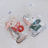 Plush bear bag charm dressed in a cozy Nordic-style sweater with knit patterns and warm tones. The bear features a soft, fluffy texture, dangling legs, and a playful expression, making it a charming accessory for bags, backpacks, or keychains.