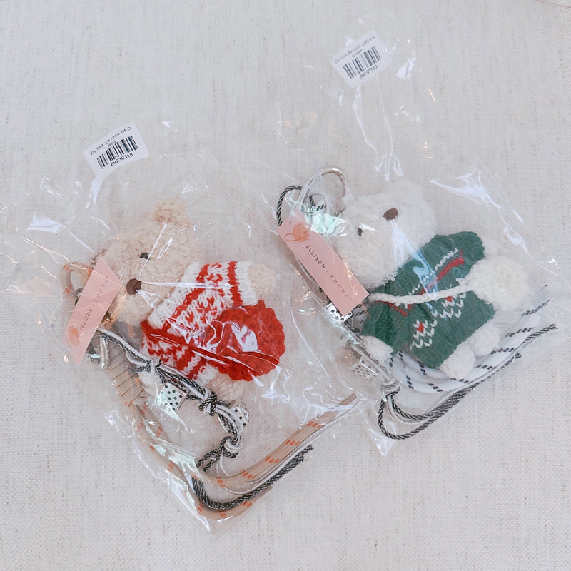 Plush bear bag charm dressed in a cozy Nordic-style sweater with knit patterns and warm tones. The bear features a soft, fluffy texture, dangling legs, and a playful expression, making it a charming accessory for bags, backpacks, or keychains.