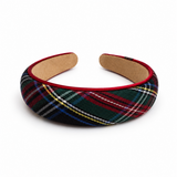 A padded fabric headband featuring a classic tartan plaid pattern in green, red, black, and white, with a red velvet inner lining and a tan cork backing, shown on a plain white background.