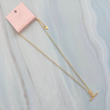 A gold chain necklace featuring a sparkling pavé T-bar pendant. The design combines a classic toggle motif with shimmering details for a sophisticated and modern finish.