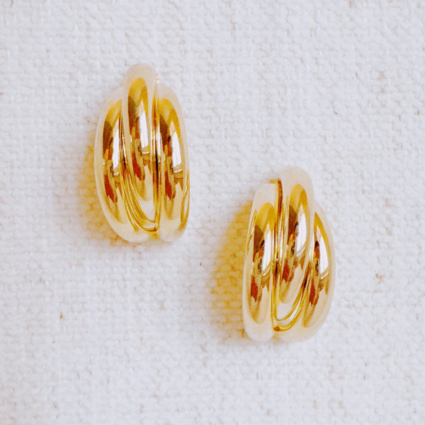 Statement earrings featuring bold interlocking loops in a polished gold-tone finish—offering a modern, sculptural look with standout appeal.