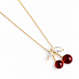 Gold necklace with cherry-shaped pendants on a white background