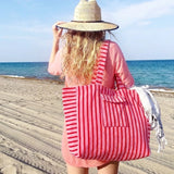 Oversized beach bag made from plush terry cloth material, designed with sturdy handles and a spacious interior—perfect for carrying towels, swimwear, and summer essentials in cozy, absorbent style.