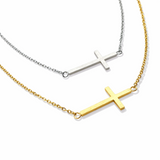 Two cross necklaces, one gold and one silver, on a white background.