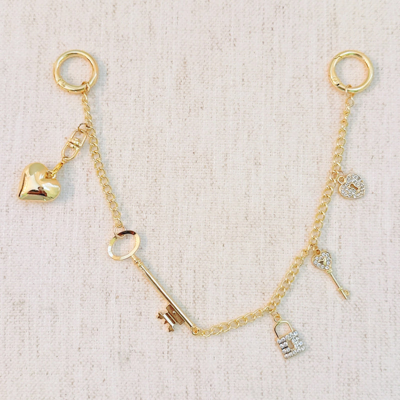 Gold bag charm with key, lock, and ring details – elegant purse accessory