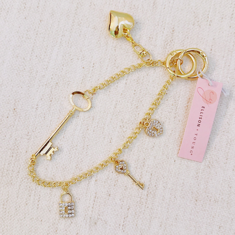 Gold bag charm with key, lock, and ring details – elegant purse accessory
