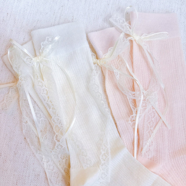 Set of two socks with lace detailing and satin bow accents at the back, offering a romantic and elegant touch to everyday looks.