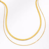 Two gold necklaces on a white background