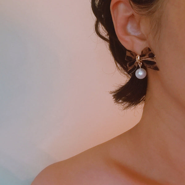 Pair of leopard-print fabric bow earrings accented with dangling pearl drops and gold-tone hardware.