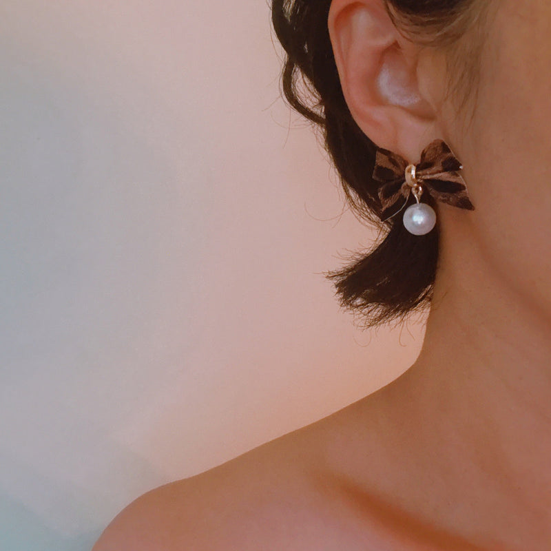 Pair of leopard-print fabric bow earrings accented with dangling pearl drops and gold-tone hardware.