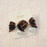 Pair of leopard-print fabric bow earrings accented with dangling pearl drops and gold-tone hardware.