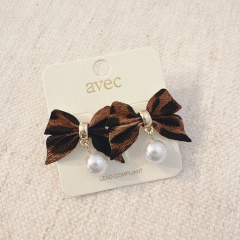 Pair of leopard-print fabric bow earrings accented with dangling pearl drops and gold-tone hardware.