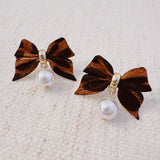 Pair of leopard-print fabric bow earrings accented with dangling pearl drops and gold-tone hardware.