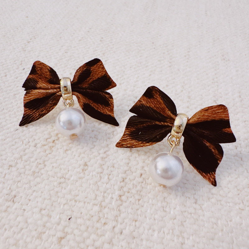 Pair of leopard-print fabric bow earrings accented with dangling pearl drops and gold-tone hardware.