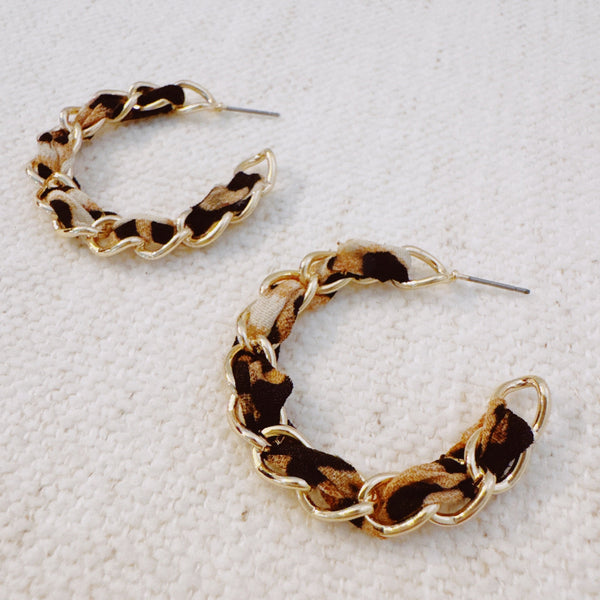 Gold chain hoop earrings wrapped with a leopard print scarf for a bold, fashion-forward statement look.