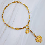 Gold-toned statement necklace featuring a bold chain and a cascading duo of engraved heart-shaped medallion pendants.