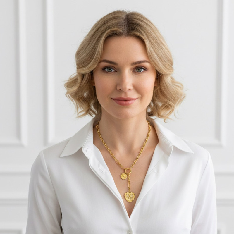 Gold-toned statement necklace featuring a bold chain and a cascading duo of engraved heart-shaped medallion pendants.