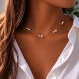 Pearl necklace worn by a person with a white shirt