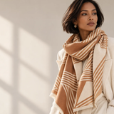 Model wearing Ellison+Young Luxe Abstract Swirl Stripe Shawl Scarf in Camel Ivory draped over an ivory coat