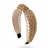 Beige woven headband with black accents on a white background