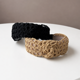 Black and beige woven headbands on a white surface with a beige background