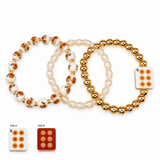 Three beaded bracelets displayed on a white background, with two overlapping bracelets above and two small inset views labeled Side A and Side B showing the square tile detail. The bracelets include white faux-pearl beads, metallic gold beads, and white beads with orange-brown speckled centers.