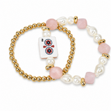 A beaded stretch bracelet featuring gold-tone ball beads, white baroque pearls, pink rose quartz beads, and a central white tile charm depicting a red and black two of clubs playing card, shown on a clean white background.