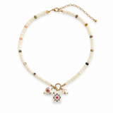 A delicate beaded necklace with small cream-colored beads, scattered gold and brown spacer beads, and a gold-tone clasp. The necklace features three charms at the center: a small pink and white floral heart, a white pearl bead, and a rectangular white charm with a colorful floral design.