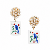 A pair of gold and pearl stud earrings featuring a white rectangular drop with an enamel playing card design of a blue bird on a green branch with red flowers.