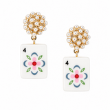 A pair of gold and white drop earrings featuring a round cluster of white faux pearls at the top and a rectangular white tile below with a colorful floral design resembling a playing card suit symbol.