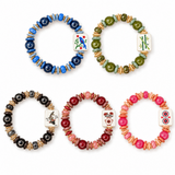 Five mahjong tile bracelets in blue, green, black, burgundy, and pink, with round beads, stone chips, gold-tone spacers, and illustrated white tilesz.