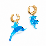 Gold hoop earrings with blue dolphin charms on a white background