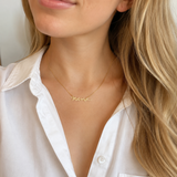 a mom wearing mama script necklace in gold