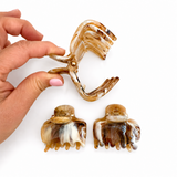 Hand holding a set of decorative hair clips with a white background