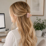 Woman with long blonde hair wearing a pink scrunchie in an office setting
