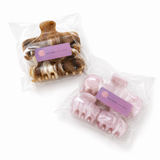 Two packages of hair clips with visible brand labels on a white background